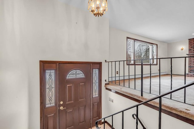 entrance foyer with a notable chandelier, stairs, and a baseboard heating unit