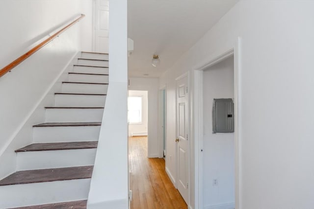 stairway with electric panel and wood finished floors