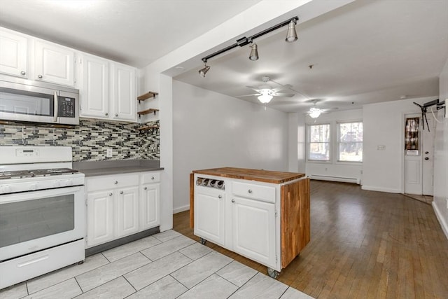 kitchen with tasteful backsplash, a baseboard radiator, white cabinetry, and white range with gas cooktop