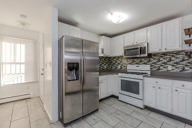 kitchen featuring dark countertops, appliances with stainless steel finishes, white cabinetry, and a baseboard heating unit