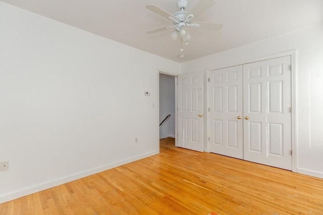 unfurnished bedroom with baseboards, light wood-type flooring, a closet, and ceiling fan