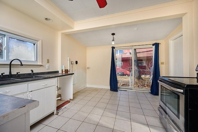 kitchen featuring sink, light tile patterned floors, decorative light fixtures, white cabinets, and stainless steel electric range