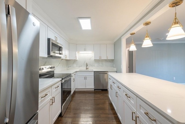 kitchen featuring decorative backsplash, white cabinetry, stainless steel appliances, and decorative light fixtures