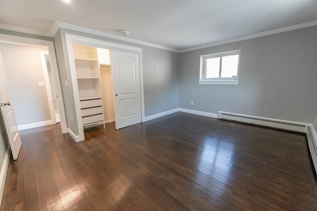 unfurnished bedroom with a walk in closet, crown molding, a closet, and dark hardwood / wood-style floors