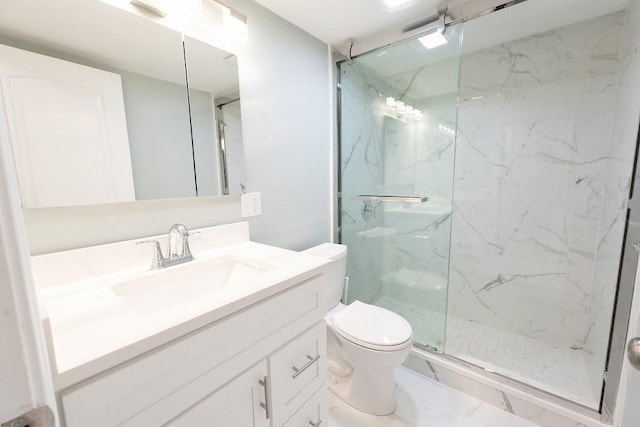 bathroom with vanity, toilet, and a shower with door