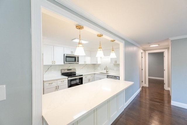 kitchen with white cabinetry, sink, hanging light fixtures, tasteful backsplash, and appliances with stainless steel finishes