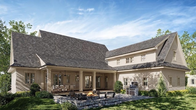 back of house with exterior kitchen, a patio area, a yard, and a fire pit