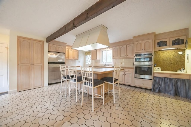 10 Victoria Cir, Norwood, MA 02062 - kitchen featuring stainless steel appliances, light brown cabinets, a kitchen breakfast bar, light countertops, and a kitchen island