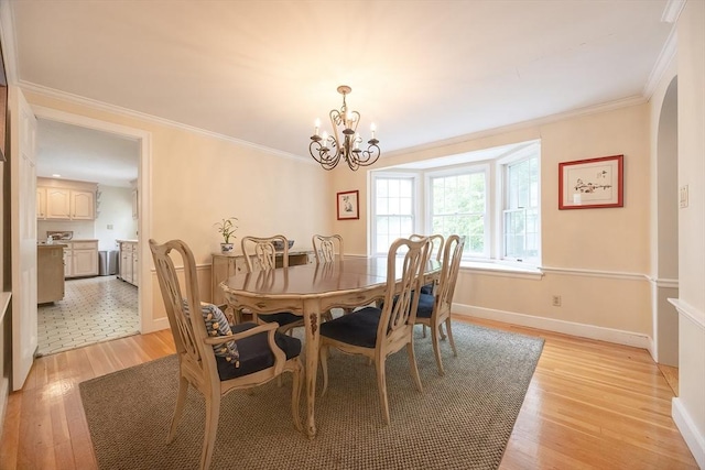 10 Victoria Cir, Norwood, MA 02062 - dining area with light wood-type flooring, a chandelier, crown molding, and arched walkways