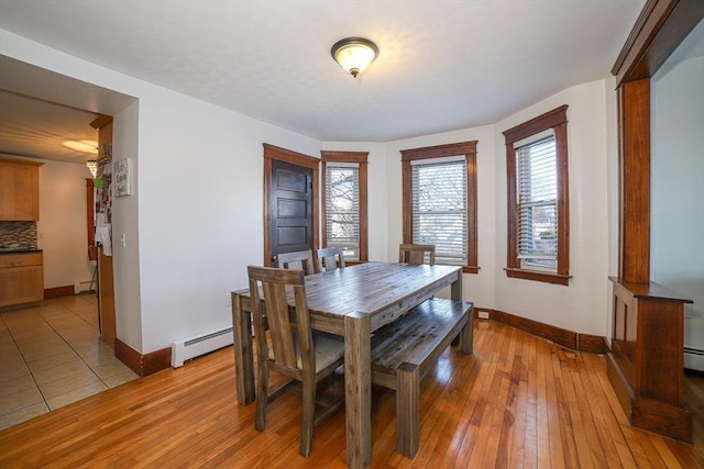 dining space with light hardwood / wood-style flooring and a baseboard radiator