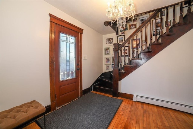 entryway featuring hardwood / wood-style flooring, a chandelier, and baseboard heating