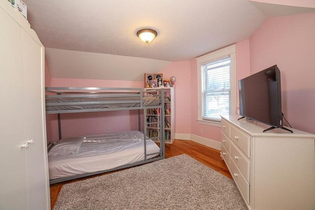 bedroom featuring lofted ceiling and light hardwood / wood-style floors