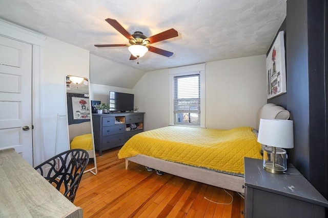 bedroom with hardwood / wood-style flooring, ceiling fan, and lofted ceiling