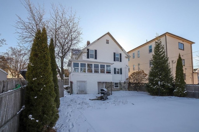 snow covered property with a sunroom