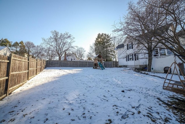 yard covered in snow with a playground