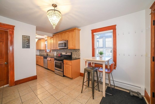 kitchen with a breakfast bar, appliances with stainless steel finishes, backsplash, a notable chandelier, and a baseboard radiator