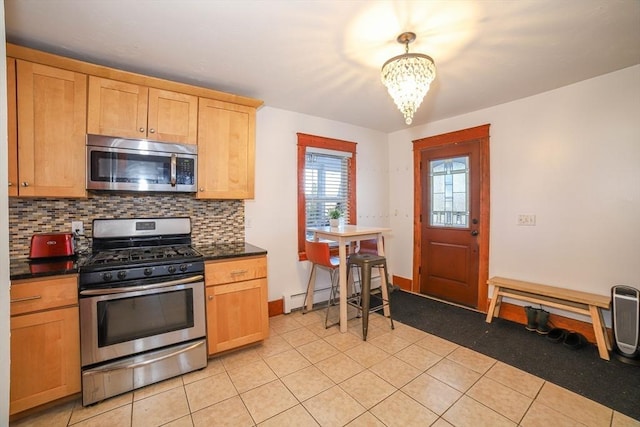 kitchen featuring tasteful backsplash, light tile patterned floors, a notable chandelier, stainless steel appliances, and a baseboard heating unit