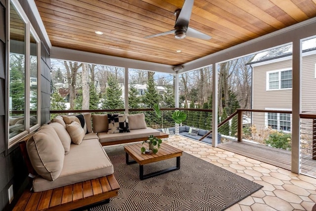 sunroom featuring wooden ceiling and a ceiling fan