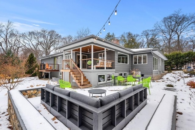 back of property featuring a chimney, stairway, and a wooden deck