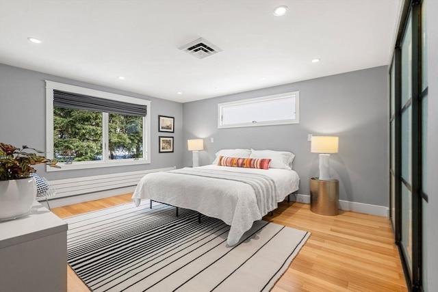 bedroom featuring light wood-type flooring, visible vents, baseboards, and recessed lighting