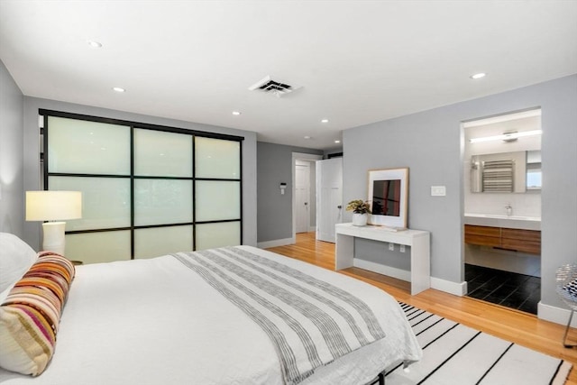 bedroom with recessed lighting, wood finished floors, visible vents, and baseboards