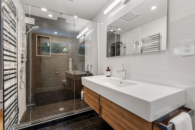 full bath with tile walls, backsplash, a shower stall, and vanity