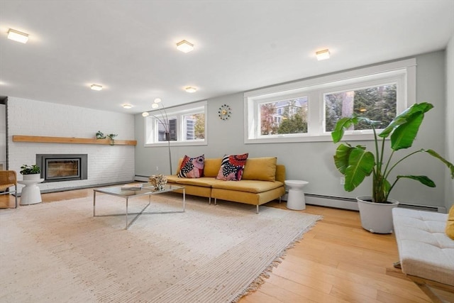 living area featuring a fireplace, a baseboard heating unit, baseboard heating, and wood finished floors