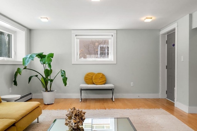 living area featuring a baseboard radiator, wood finished floors, and baseboards