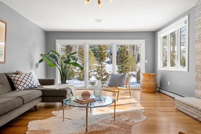 interior space featuring visible vents, baseboard heating, and wood finished floors