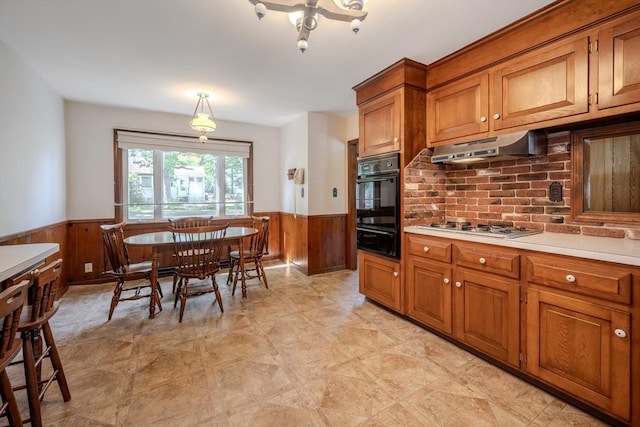 10 Primrose Rd, Billerica, MA 01821 - kitchen featuring oven, a wainscoted wall, under cabinet range hood, a warming drawer, and wooden walls