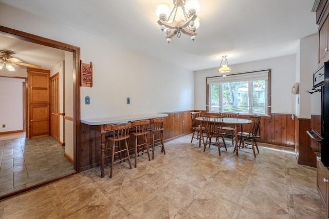 10 Primrose Rd, Billerica, MA 01821 - dining room featuring wainscoting, wooden walls, a chandelier, and ceiling fan