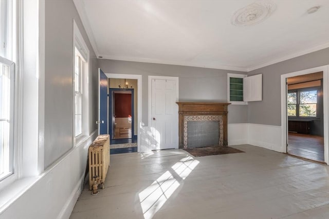 490 Plymouth, Bridgewater, MA 02324 - unfurnished living room with radiator heating unit, crown molding, a fireplace with flush hearth, a wainscoted wall, and wood finished floors