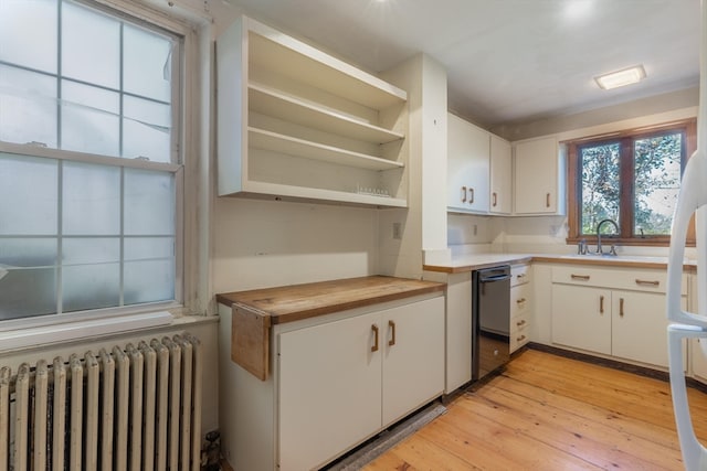 kitchen with white cabinets, radiator heating unit, light hardwood / wood-style floors, and wood counters