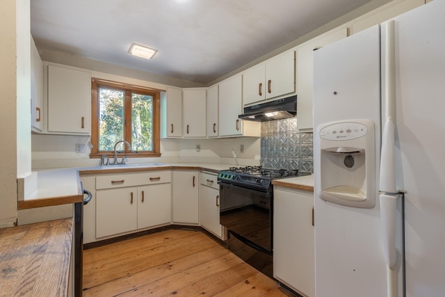 kitchen featuring black stove, white cabinets, light wood-type flooring, and white fridge with ice dispenser