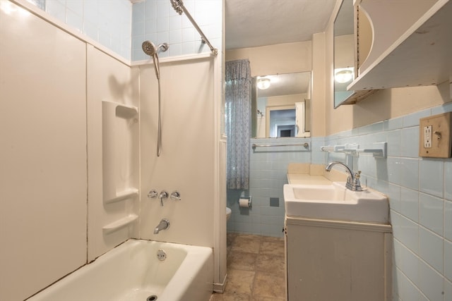 full bathroom featuring vanity, tile walls, toilet, and washtub / shower combination