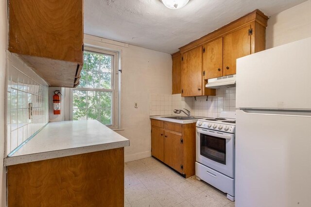 490 Plymouth, Bridgewater, MA 02324 - kitchen with white appliances, light flooring, under cabinet range hood, light countertops, and brown cabinetry