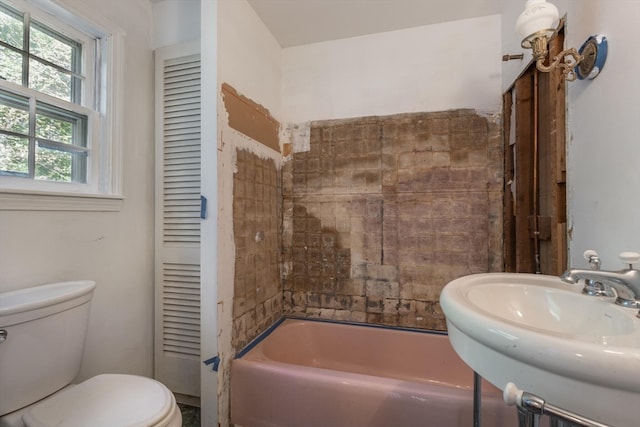 full bathroom featuring toilet, tiled shower / bath combo, and sink