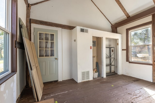 interior space with lofted ceiling with beams, plenty of natural light, and dark hardwood / wood-style flooring