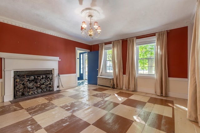 unfurnished living room featuring ornamental molding, a notable chandelier, a fireplace, and radiator