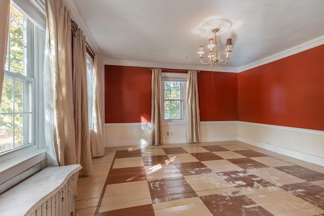 empty room featuring a notable chandelier and ornamental molding