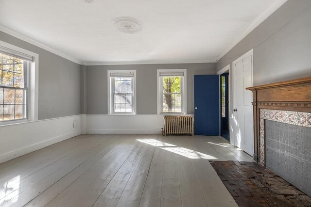 490 Plymouth, Bridgewater, MA 02324 - unfurnished living room with radiator, ornamental molding, a fireplace with flush hearth, wood-type flooring, and a wainscoted wall