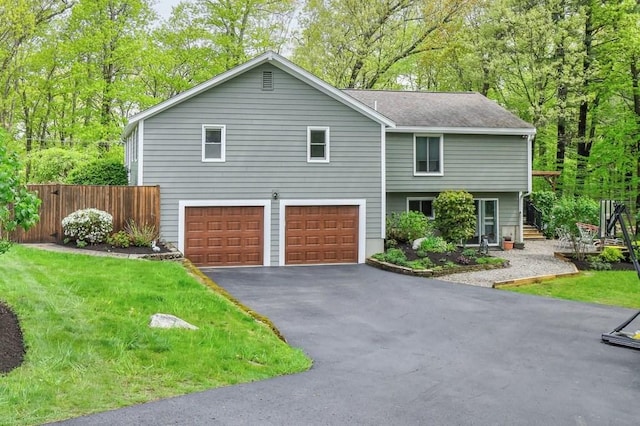 view of front of property with an attached garage, driveway, roof with shingles, and fence