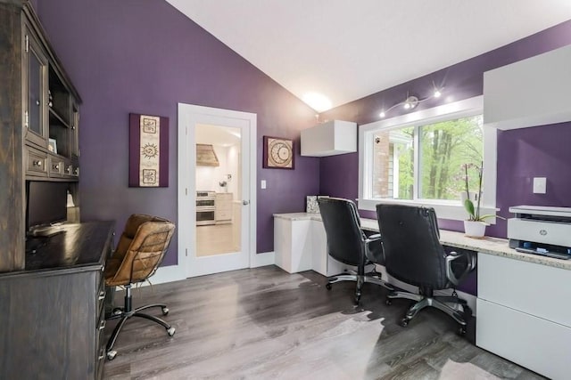 office area with dark wood-style floors, vaulted ceiling, and baseboards