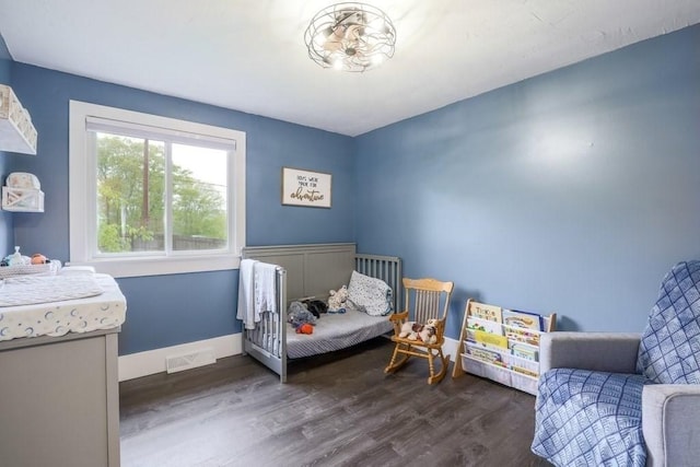 bedroom with dark wood-type flooring and baseboards