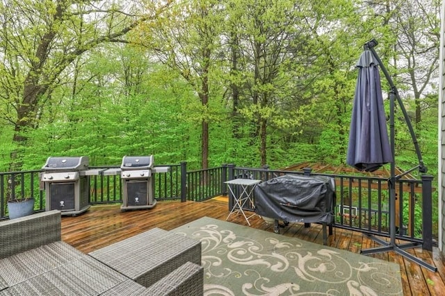 deck with area for grilling and a forest view