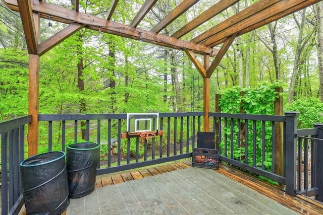 wooden terrace with a pergola and a wooded view