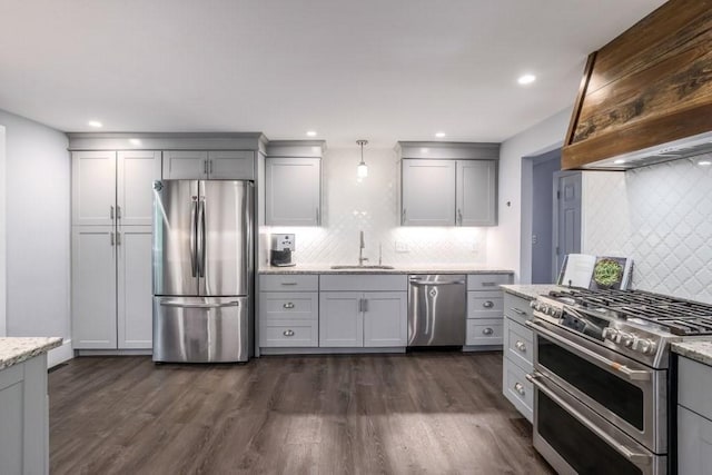 kitchen featuring appliances with stainless steel finishes, tasteful backsplash, gray cabinets, a sink, and light stone countertops