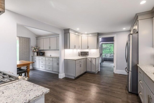 kitchen featuring stainless steel appliances, gray cabinets, backsplash, dark wood finished floors, and recessed lighting