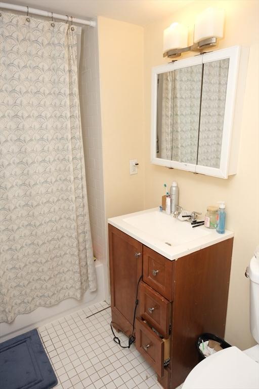 287 W 5th St, Boston, MA 02127 - full bath with toilet, vanity, tile patterned floors, and shower / bath combo with shower curtain
