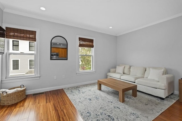 living room with ornamental molding, wood finished floors, baseboards, and recessed lighting